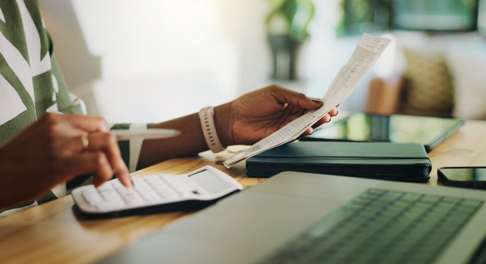 Finance-calculator-and-hands-with-receipt-