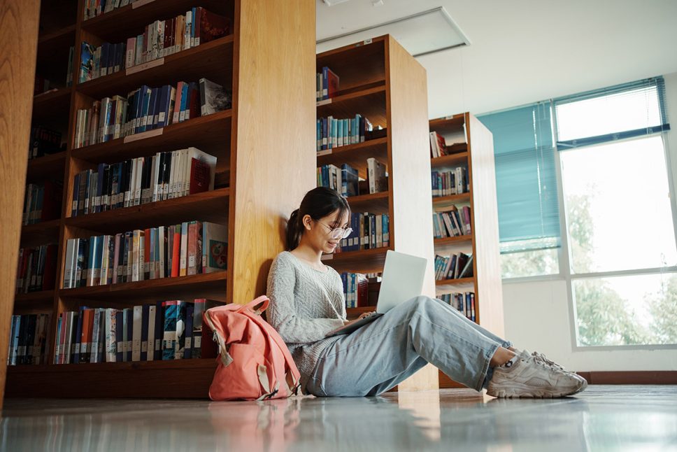 Student-girl-sitting-on-floor-and-using-laptop